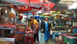 A Thai woman walks between stalls in a market in Thailand